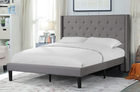 Gray upholstered bed with tufted headboard in a bedroom setting