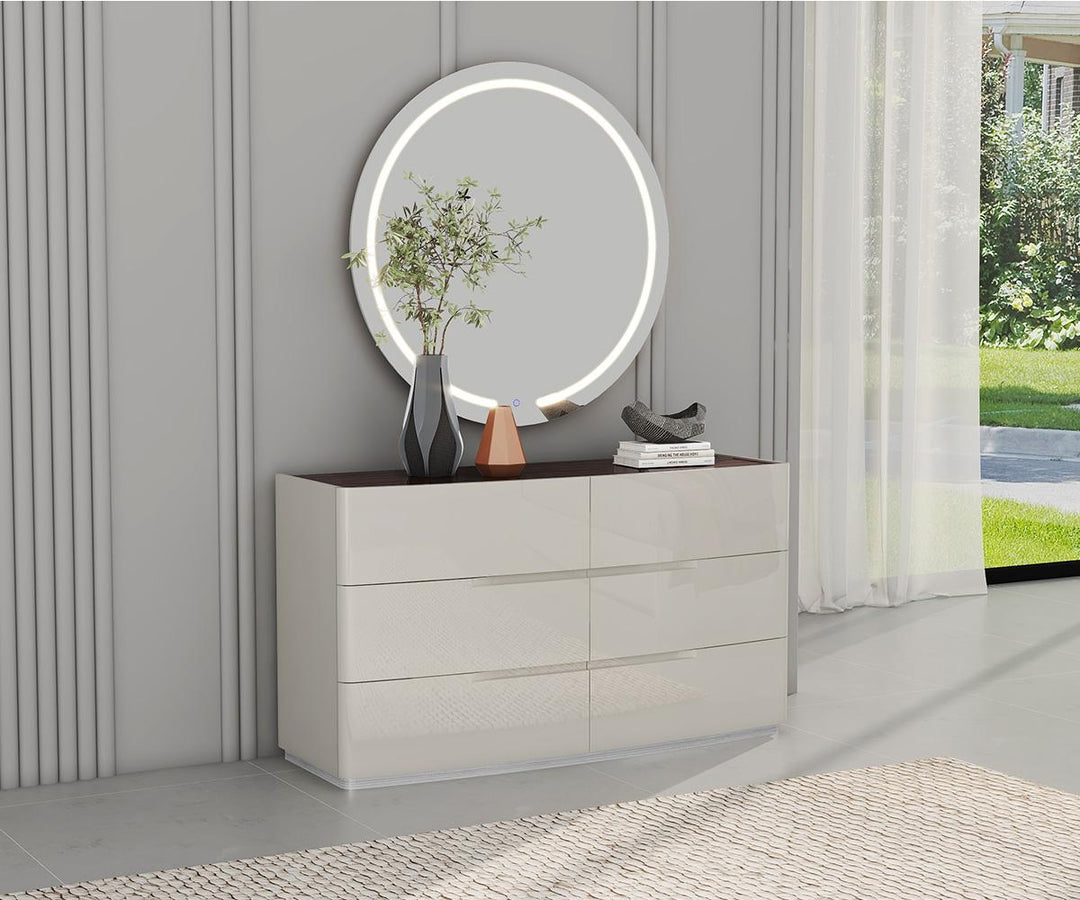 Modern dresser with round mirror and decorative items in a room with gray walls and a window.