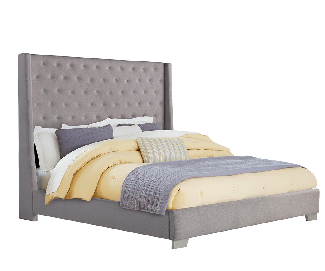 Gray upholstered bed with yellow and gray bedding on a white background