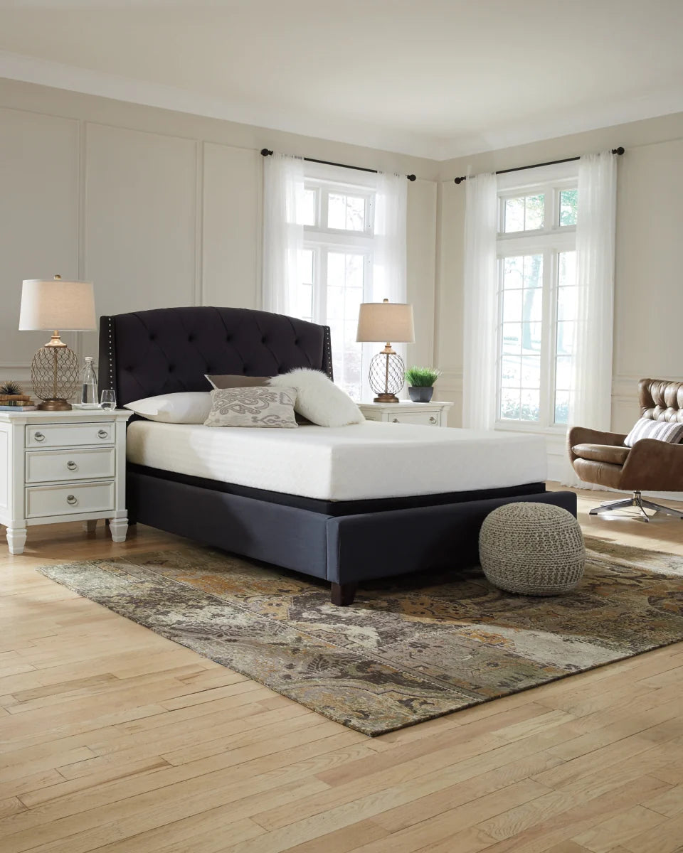 Modern bedroom with a black upholstered bed, white bedding, and decorative elements.